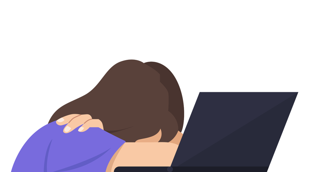 An unfortunate part of many people's "age regression story" is bullying. Here's an illustration of a person with long brown hair hunched over their desk with their head in their arms. Their laptop is open, and they seem upset about what's on it.